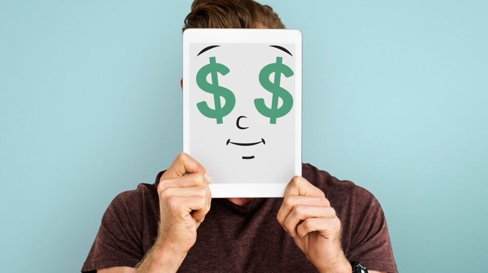 Um homem segurando um quadro com um desenho com um rosto feliz.